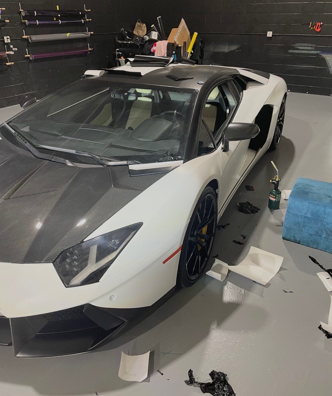 Lamborghini Aventador in gloss white with exposed carbon fiber, mid-install